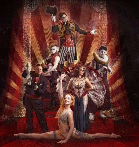 A man in a black coat and a mask is embracing a woman with curly hair who is wearing an elegant dress. In the man's hand, there is a candlestick with burning candles.