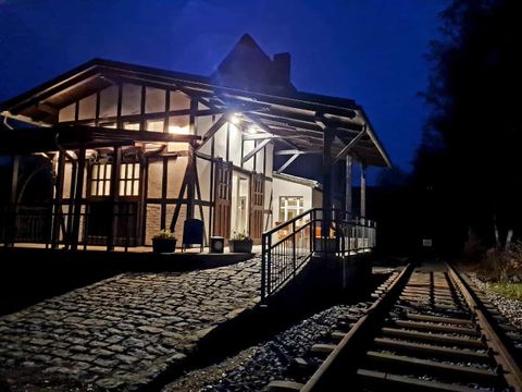 oud treinstation, verlicht, daarnaast loopt een spoor langs