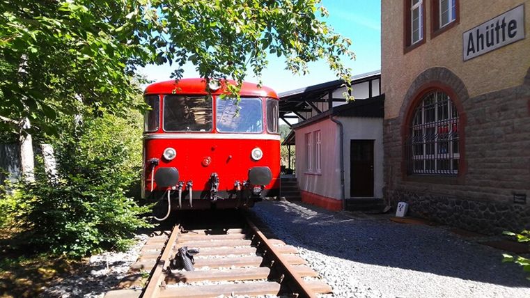Exterior view of the museum building. In front of it stands an old red steam locomotive.