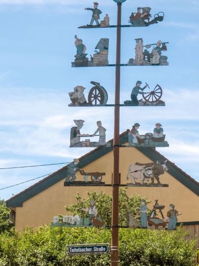 Een traditionele meiboom met handgemaakte figuren voor een huis in Trimport.