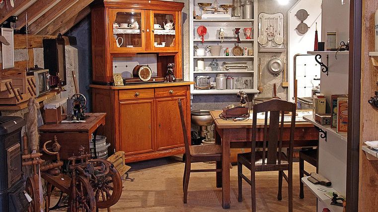 Vue intérieure du petit musée avec des meubles anciens et des objets ménagers.