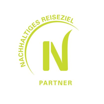 A logo for sustainable tourism. It features the inscription "Sustainable Destination" and the word "Partner" in a modern design.