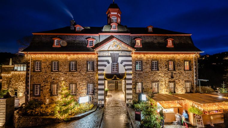 Burgbrohl Castle in winter, with Christmas lights and decorative lights that warmly illuminate the historic walls