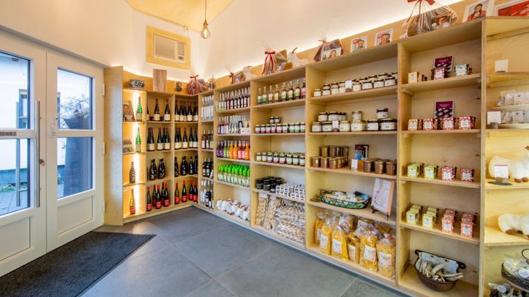 Einladender Verkaufsraum mit Regalen voller Lebensmittel und Getränken. Die Wände sind hell und freundlich gestaltet, was eine angenehme Atmosphäre schafft.