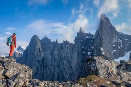 Eine beeindruckende Wüstenlandschaft mit roten Felsen und monumentalen Tafelbergen. Der klare Himmel ergänzt die rustikale Schönheit der Umgebung.