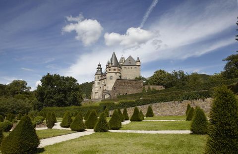Bürresheim Castle near Mayen with Baroque garden. The sky is blue with white clouds.
