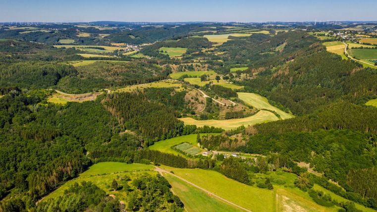 Aerial view of the green, hilly landscape of the Brommert Heights in the Eifel.