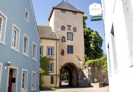 L'Oberes Tor à Dudeldorf, une porte historique de la ville, entourée de maisons colorées et d'une plaque de rue. Journée ensoleillée avec un ciel bleu., © Tourist-Information Bitburger Land_M. Mayer