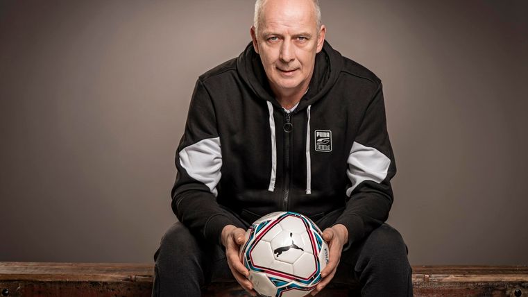 Zittende man met een bal in zijn hand