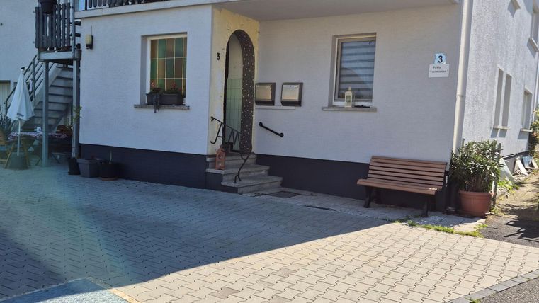 Ein modernes Wohnhaus mit einem Balkon und einer gepflasterten Einfahrt. Der Außenbereich ist sauber und einladend.