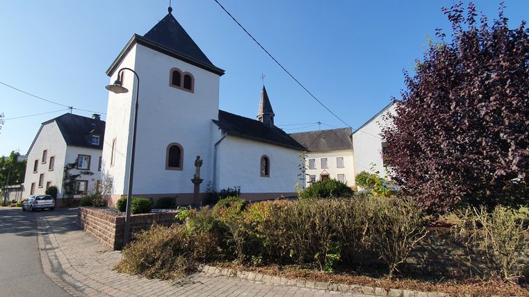 Kapel van St Lucia in een dorp met een blauwe lucht.