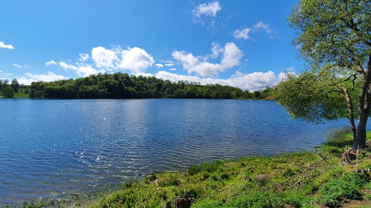 Un couple marche main dans la main à travers un étroit tunnel de pierres éclairé. L'atmosphère semble aventureuse et intéressante.