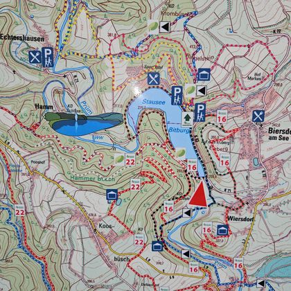 Eine detaillierte Wanderkarte mit verschiedenen Wegen und markierten Punkten. Es zeigt auch einen See und Parkmöglichkeiten in der Umgebung.