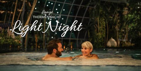 Two people in the pool at night