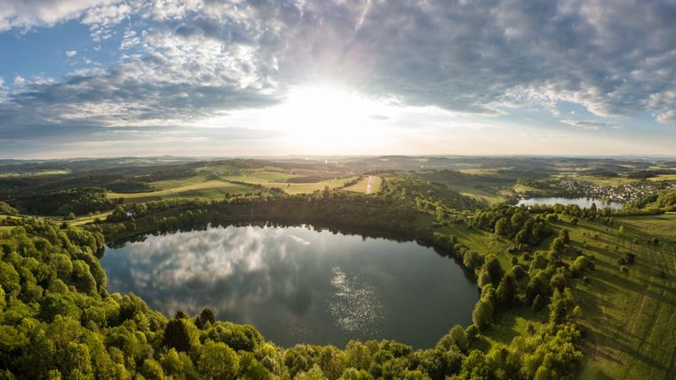 Luchtfoto van twee maars in een groen landschap bij zonsondergang.