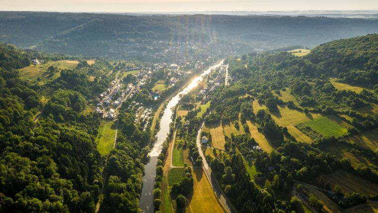 Luchtfoto van de Sûrevallei met rivier en omliggende bossen en velden.