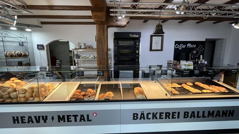 Interieur bakkerij in wit met houten balken, toonbank met bakkerswaren