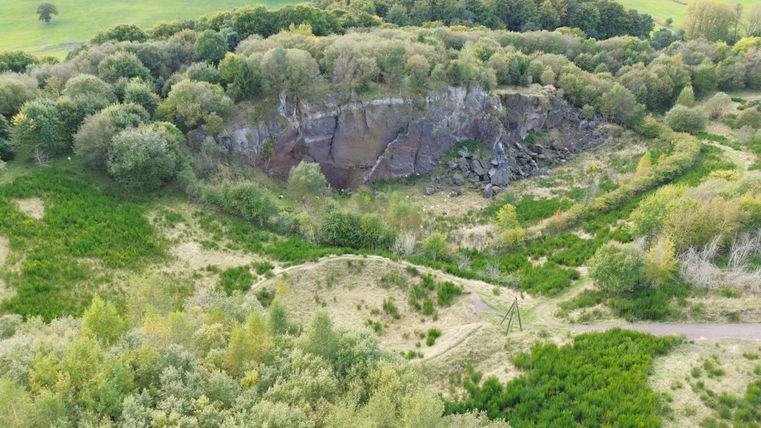 Aerial view of the wooded area with the rock face of the Steffelberg and green meadows.