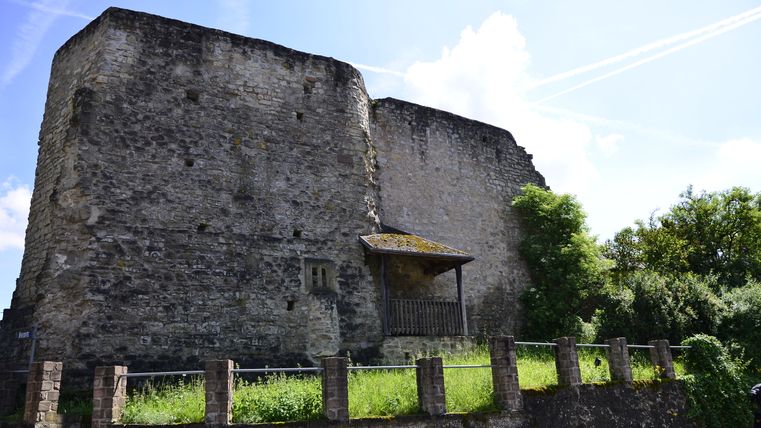 Ruine der Burg Bettingen mit alten Steinmauern und umgebender Vegetation.