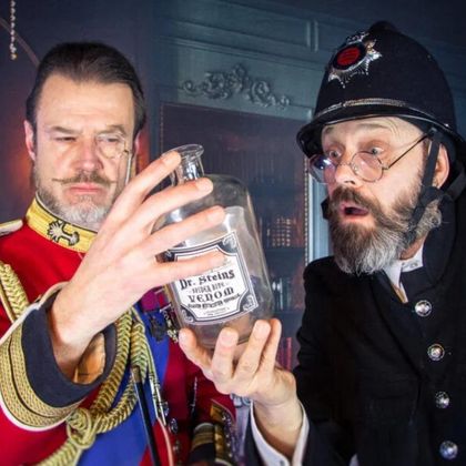 Een historisch gebouw 's nachts met rode ramen en een donkere achtergrond. De scène wordt verlicht door het warme licht van de straatlantaarns.