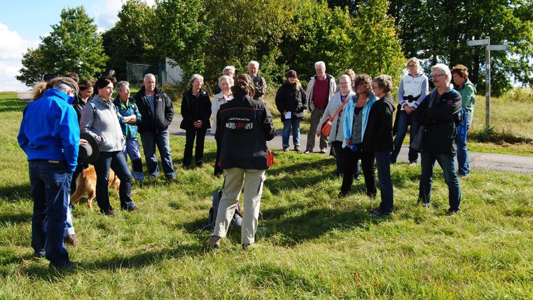 guide criminelle qui explique quelque chose à un groupe de randonneurs