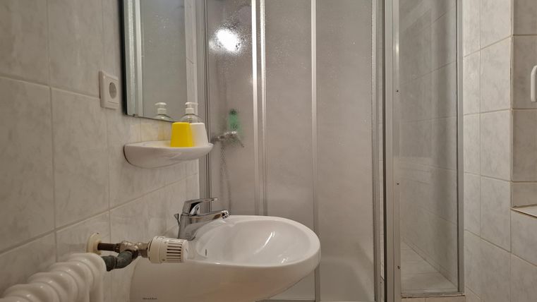 A small bathroom with a shower and a sink.