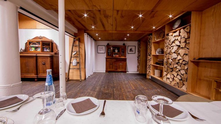 Ein einladender Raum mit Holzmöbeln und einem schönen, rustikalen Flair. Der Tisch ist gedeckt und wirkt bereit für eine Mahlzeit.
