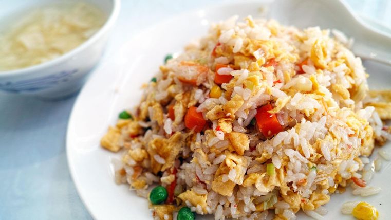 Symbol picture - A rice dish with peas, corn, and bell peppers is on a white plate.