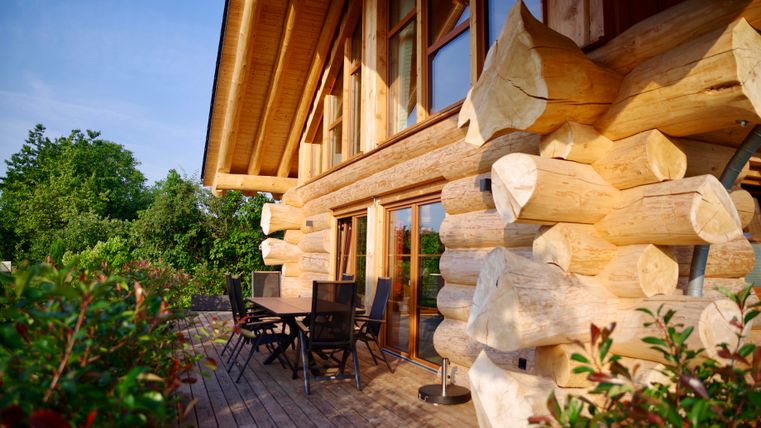Une terrasse en bois confortable avec une table de jardin et 6 chaises.