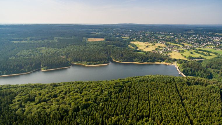 Vue aérienne du barrage de Dreilägerbach avec les forêts et les champs environnants.