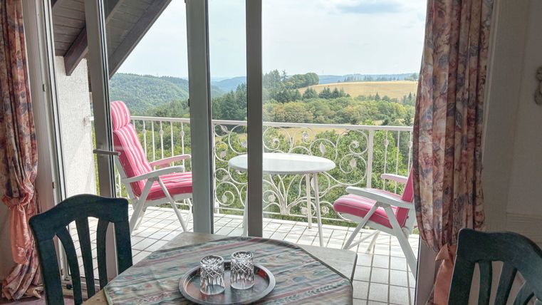 Een gezellige kamer met uitzicht op het landschap. Twee stoelen staan op het balkon, ideaal om te ontspannen.