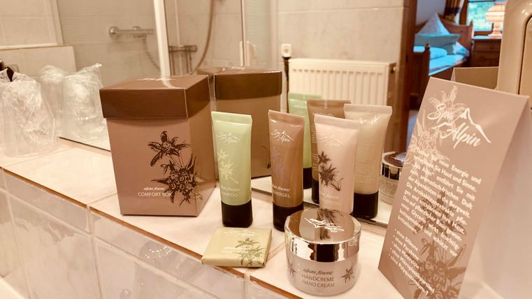 Een luxe set met verzorgingsproducten op een badkamer wastafel. De producten zijn in stijlvolle verpakkingen gerangschikt en omvatten crème en lotions.
