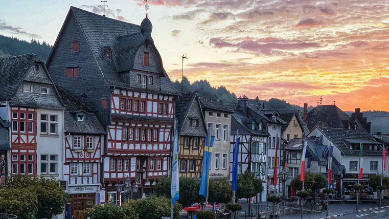 Vakwerkhuizen op het marktplein in Adenau bij zonsondergang.