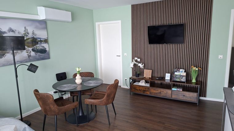 Ein modernes Wohnzimmer mit einer gemütlichen Sitzecke und einem Esstisch.