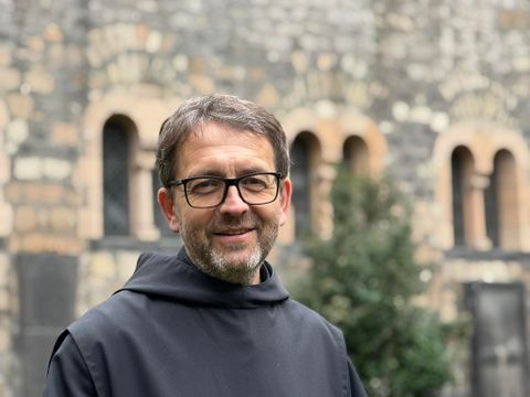 Ein schöner Innenhof mit einem Brunnen und grünen Pflanzen. Die Bogenarchitektur verleiht einen historischen Charme.