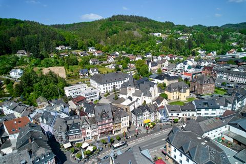 Main street with houses in Adenau in the background forest 