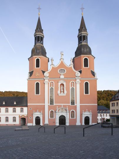 Eine beeindruckende Kirche mit zwei Türmen und einer rosa Fassade. Der Platz vor der Kirche ist weit und ruhig.