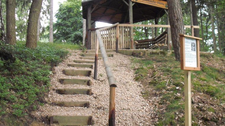Treppenstufen mit Geländer zur offenen Hütte auf dem Wanderweg