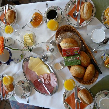 Een uitgebreid ontbijtbuffet met broodjes, worst, kaas en eieren. Daarbij serveren we koffie, sap en verschillende jamsoorten.