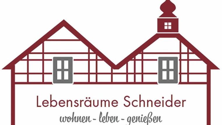 Un logo avec deux maisons stylisées de style à colombages. En dessous se trouve "Lebensräume Schneider" avec le slogan "habiter - vivre - profiter".