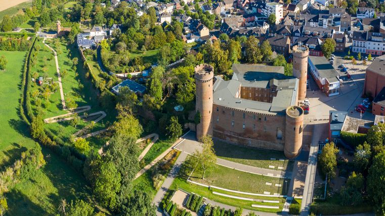 Aerial view of Zülpich Castle with surrounding park and town center.