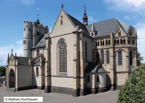 An impressive church with Gothic and Romanesque elements. The building has several towers and large windows, the architecture is diverse and historic.