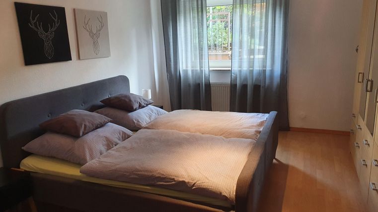 A modern bedroom with a large double bed and cozy pillows.