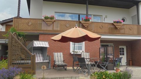 Eingang und Terrasse der Ferienwohnung Nürburgblick mit Strandkorb und Gartenmöbel