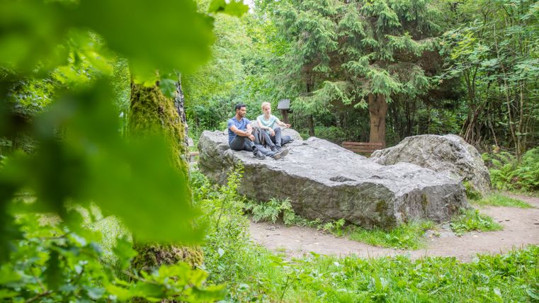 Zwei Personen sitzen auf einem Stein (Kaiser Karls Bettstatt)
