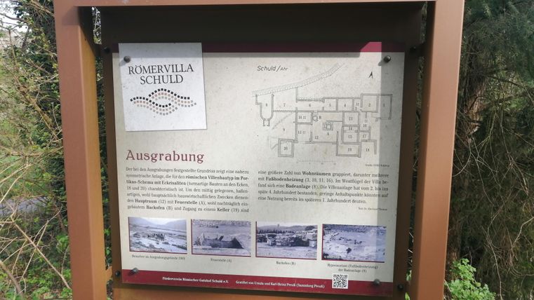 An information sign about the excavation of the Roman villa in Schuld. It displays a map and images that represent the archaeological finds.