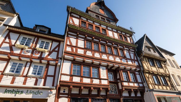 Ein historisches Fachwerkhaus mit einem auffälligen Dach und bunten Fenstern. Die Architektur zeigt den typischen Stil der Region.