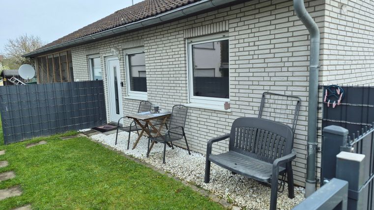 Een gezellig huis met een kleine tuin. Buiten staan zitgelegenheden en het buitengebied is goed onderhouden.