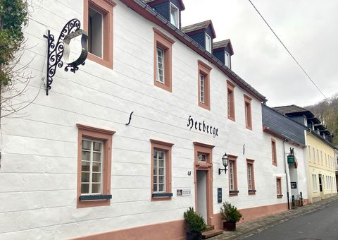 A charming building with a white façade and pink accents. It bears the sign "Hostel" and is located in a quiet street.