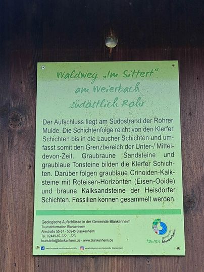 Ein Informationsschild über einen Waldweg am Weierbach. Es beschreibt die geologischen Schichten und Merkmale der Umgebung.